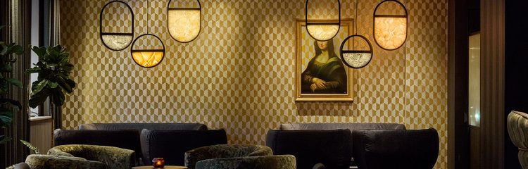 Hotel Frankfurt Metropolitan lounge Hotel Frankfurt Metropolitan The Cloud An elegant hotel lounge with dark sofas, stylish wall lighting and patterned wallpaper, creating a cosy atmosphere for relaxed conversations or breaks.